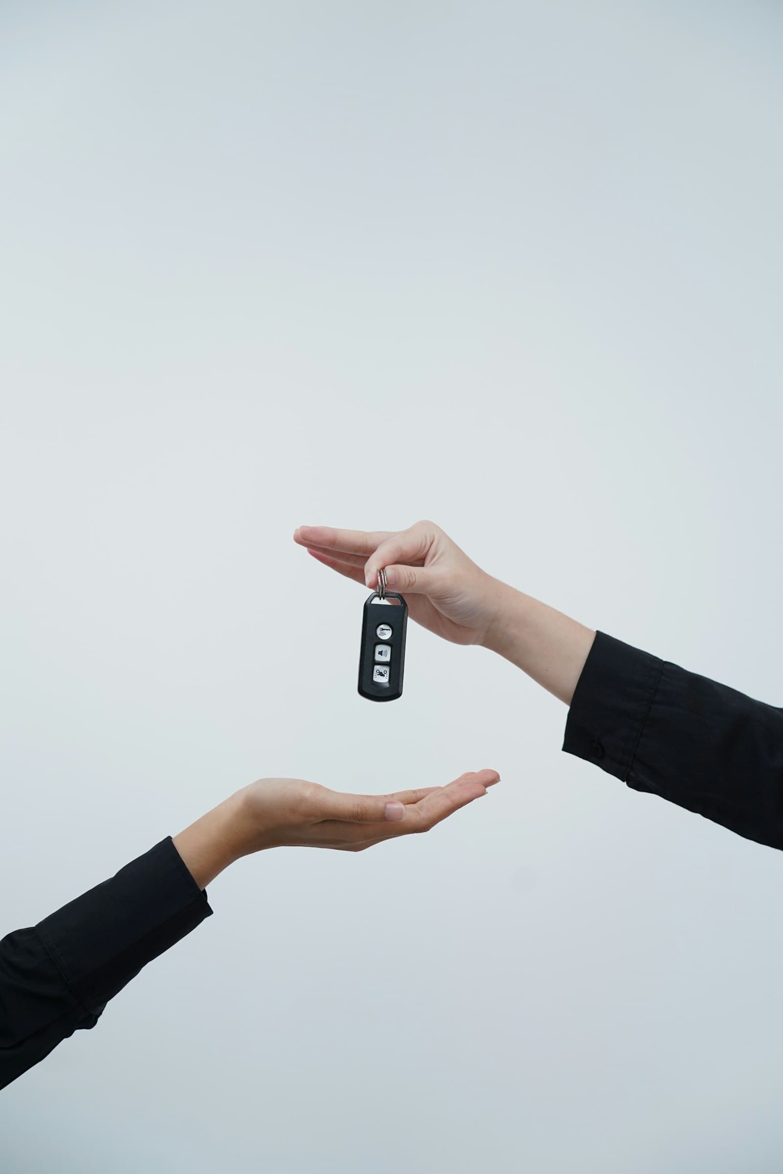 A car key being handed from one person to another
