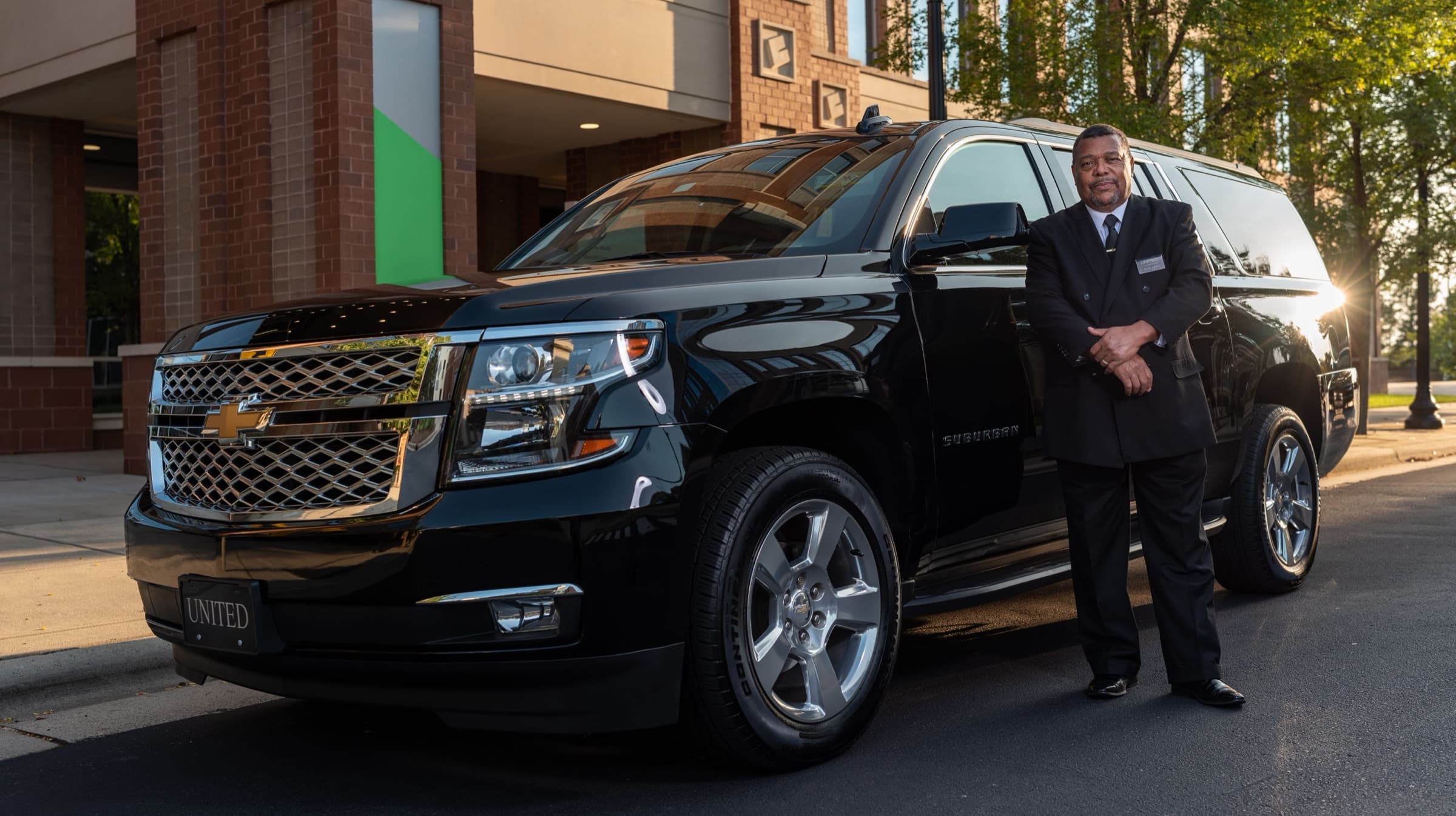 Chauffeur beside a black executive SUV in Dubai